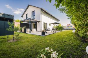 a house with a green yard with a house at Strandgeflüster deluxe in Zingst