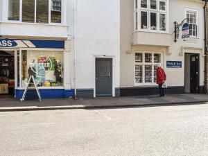 a person standing on a sidewalk in front of a store at The Photographer's House in Southwold +22 photos