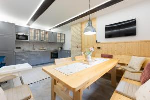 a kitchen with a wooden table and a dining room at Chaloupka u Borovků in Vyskeř