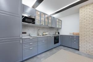 a kitchen with blue cabinets and a brick wall at Chaloupka u Borovků in Vyskeř