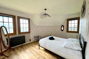 a bedroom with a bed in a room with windows at Chaumière cosy avec SPA Baie de somme in Abbeville +30 photos