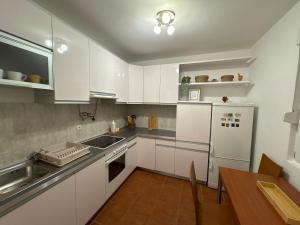 a kitchen with white cabinets and a wooden table at Boke vidik in Savina