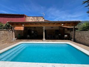 a swimming pool in front of a house at Casa Rural Valle del Jerte in Jerte