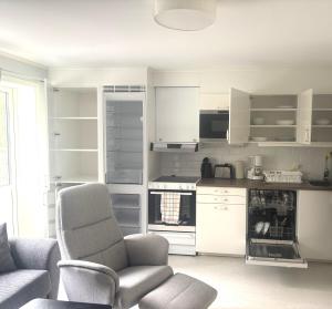 a living room with a chair and a kitchen at Björklunden in Sollefteå