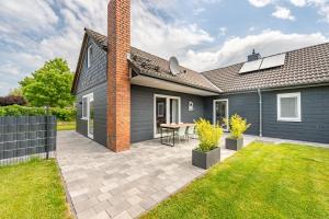 a house with a patio in the yard at Cottage am Deich Whg Mareile in Uelvesbüll