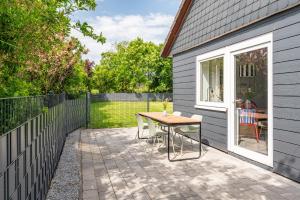 a patio with a table and a fence at Cottage am Deich Whg Marlene in Uelvesbüll