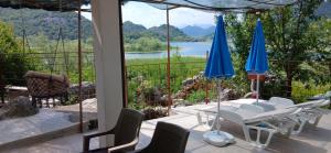 a patio with chairs and umbrellas and a view of a lake at Feel the Karuch in Karuč