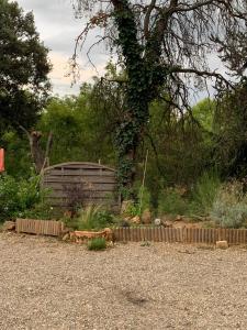 a garden with a wooden fence and a tree at Le Chalet in Taillet +2 photos