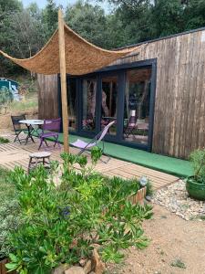 a small house with a grass roof on a wooden deck at Le Chalet in Taillet