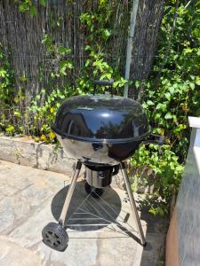 a grill sitting on a stand on a patio at Villa Aspri in Nea Kallikrateia