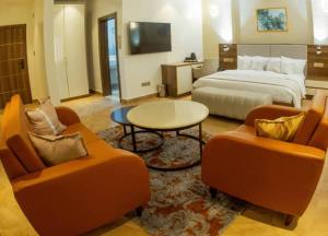 a hotel room with a bed and two chairs and a table at CARITAS HOTEL AND suite in Araromi