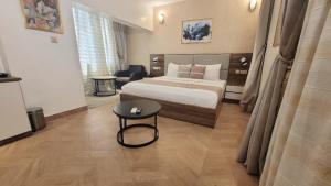 a bedroom with a bed and a table in it at CARITAS HOTEL AND suite in Araromi