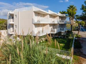a white building with a fence in front of it at PJ Properties Studio in Sounio steps away from the beach in Sounio