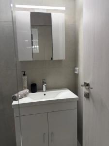 a bathroom with a white sink and a mirror at PJ Properties Studio in Sounio steps away from the beach in Sounio