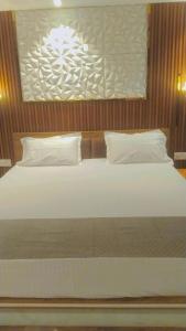 a bedroom with a bed with white pillows and avertisement at Celestia peaks in Bhowāli