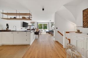 an open kitchen and living room with white cabinets at Strandwächter in Hörnum