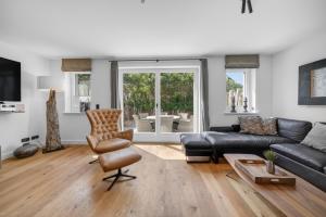 a living room with a leather couch and a chair at Strandwächter in Hörnum