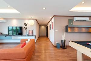 a living room with a couch and a pool table at Capitel Ekkamai Hotel in Sathani Khlong Tan