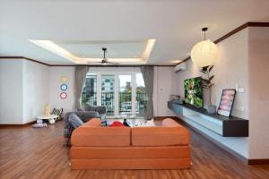 a living room with an orange couch in a room at Capitel Ekkamai Hotel in Sathani Khlong Tan