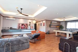 a living room with couches and a ping pong table at Capitel Ekkamai Hotel in Sathani Khlong Tan