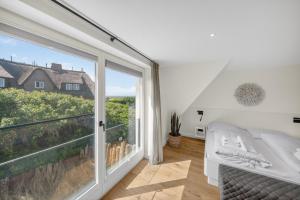 a bedroom with a bed and a large window at Strandwächter in Hörnum