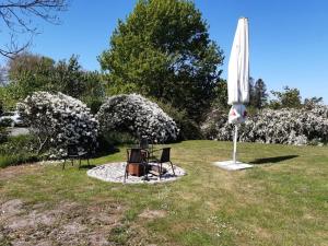 an umbrella and two chairs and a table and a table and chairs sidx sidx sidx at Luxuswohnung, 90 qm, Balkon, beste Lage in Kollmar in Kollmar
