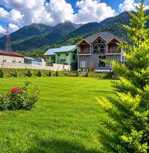 a house in a yard with a green lawn at Pahadon Ka Ghar in Sonāmarg