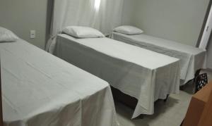 two beds in a hospital room with white sheets at Hotel Paris in Balsas