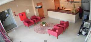 an overhead view of a waiting room with red chairs and a table at Hotel Paris in Balsas
