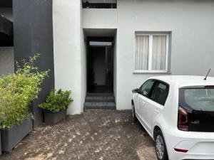 a white car parked in front of a white house at Dazio Exclusive Rooms in Rome
