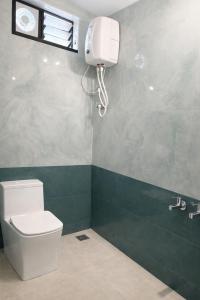 a bathroom with a toilet and a water tank at Vriksha Heritage Farm Stays in Sethumadai