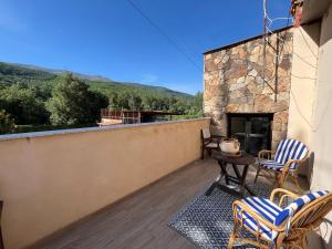 a balcony with chairs and a table and a fireplace at Casa Rural Valle del Jerte in Jerte