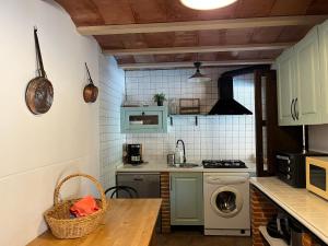 a kitchen with a sink and a washing machine at Casa Rural Valle del Jerte in Jerte