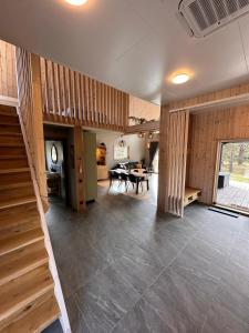 a living room with a staircase and a dining room at Jūrmalciema Pērle AMBER in Jūrmalciems +5 photos