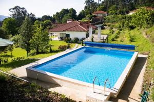 a swimming pool in the backyard of a house at Quinta da Caselinha in Paredes de Coura