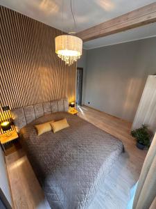a bedroom with a large bed with two yellow pillows at Jūrmalciema Pērle AMBER in Jūrmalciems
