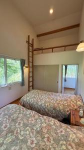 a bedroom with two beds and a bunk bed at Garden Villa Minamiaso in Minami Aso