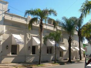 a white building with palm trees in front of it at Hotel San Jorge in Paraná