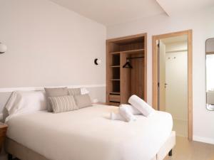a white bedroom with a large white bed at Meral Units in Fuengirola
