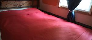 a red bed in a red bedroom with a window at le 130 mobile home à Meschers sur Gironde au camping L'escale in Meschers-sur-Gironde