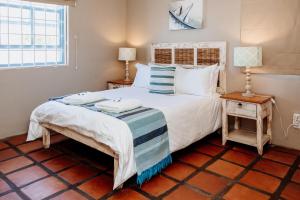 a bedroom with a bed with two towels on it at Duifie in Paternoster