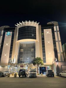a large building with cars parked in front of it at جولدن نيو الدار للشقق المخدومة in Jazan