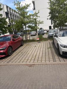 two cars parked next to each other on a parking lot at MIŁO Apartament Zarembowicza in Wrocław