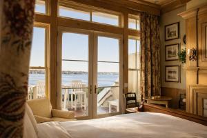 a bedroom with a bed and a view of the ocean at The Chanler at Cliff Walk in Newport
