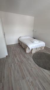 a bedroom with a bed and a wooden floor at Björklunden in Sollefteå