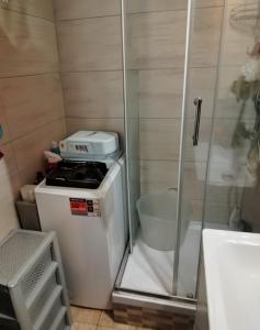 a small bathroom with a stove and a shower at Sleep & Chill in Leszno