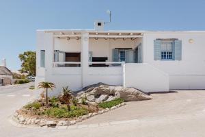 a white house with a palm tree in front of it at Duifie in Paternoster