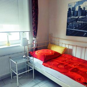 a bedroom with a bed with red sheets and a window at Herzog-Reichard in Simmern