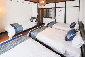 a bedroom with three beds in a room at 宿丸一 in Tajimi