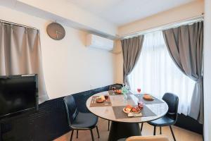 a room with a table and chairs and a television at 宿丸一 in Tajimi